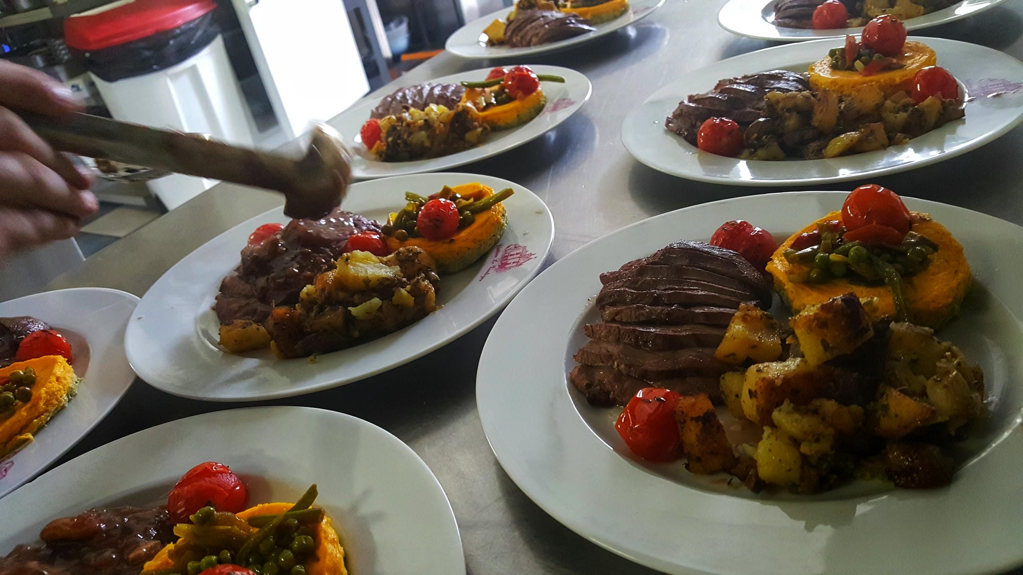 Plusieurs assiettes dressées sur une table, préparation d'un banquet au restaurant du Château le Verdoyer