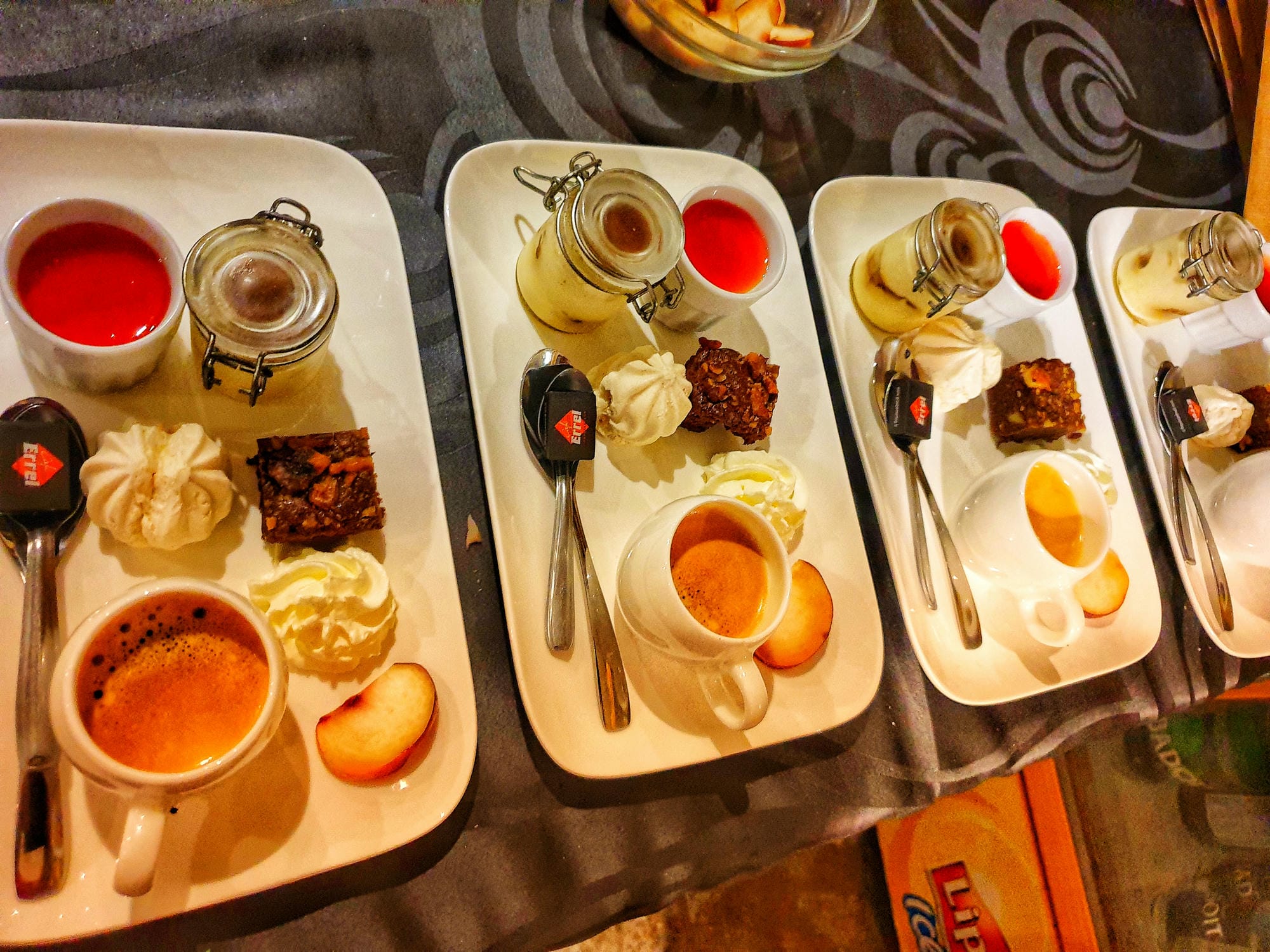 Plusieurs assiettes de mets variés disposées sur une table avec un verre de vin, banquet au Verdoyer