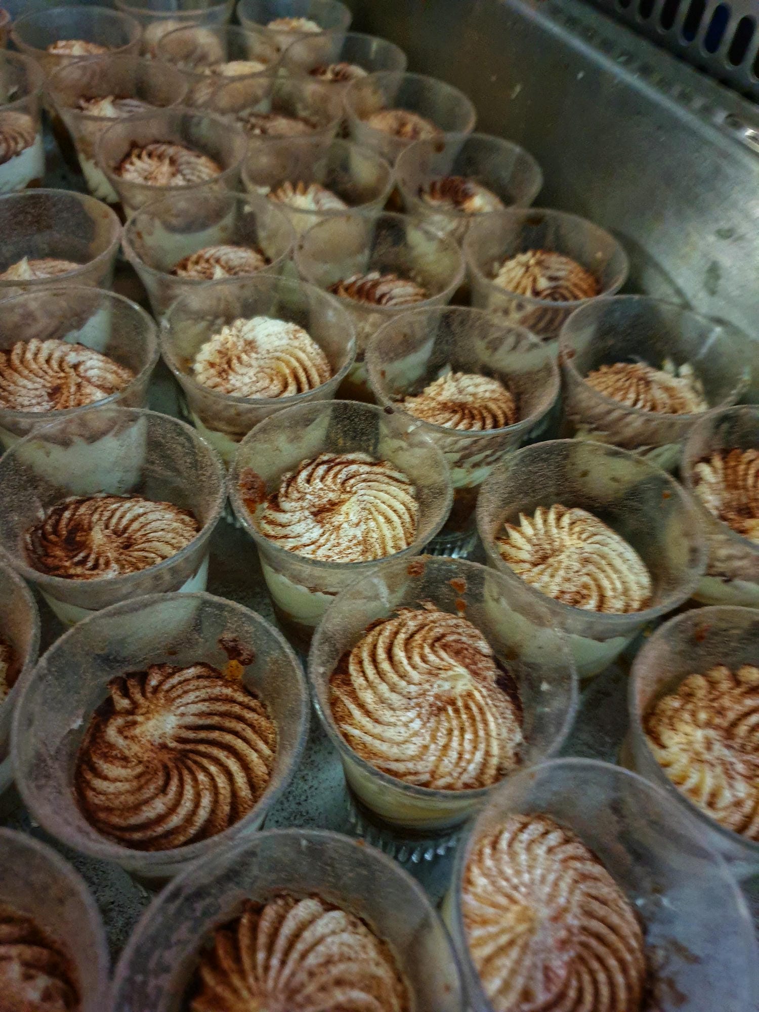 Nombreuses verrines de desserts dans une vitrine, buffet de mignardises pour banquet au Château le Verdoyer