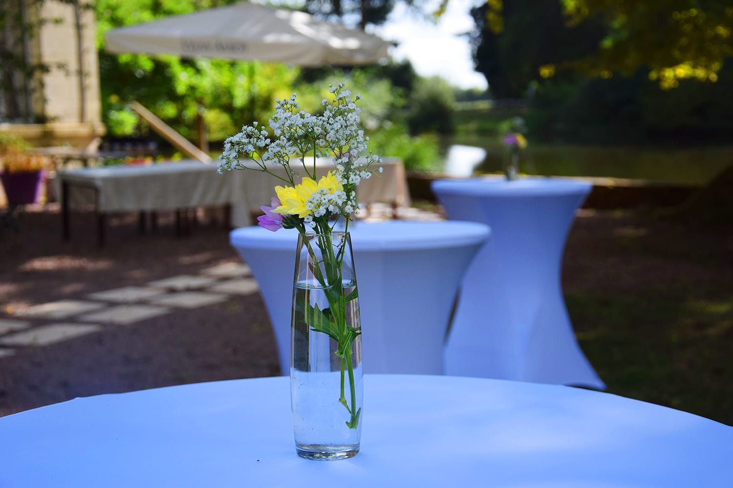 Vase de fleurs sur une table en extérieur, décoration de mariage au Château le Verdoyer