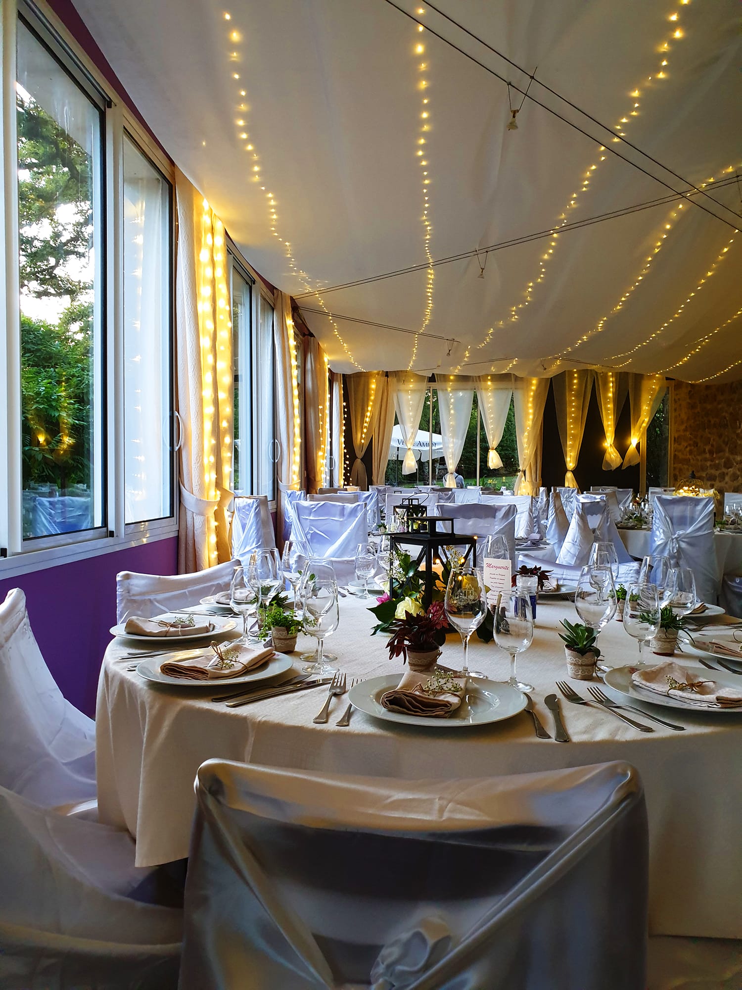 Tables dressées avec nappes et linge blancs pour une réception de mariage au Château le Verdoyer