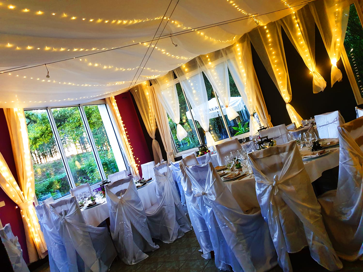 Salle de réception avec tables et chaises recouvertes de nappes blanches pour un mariage au Verdoyer