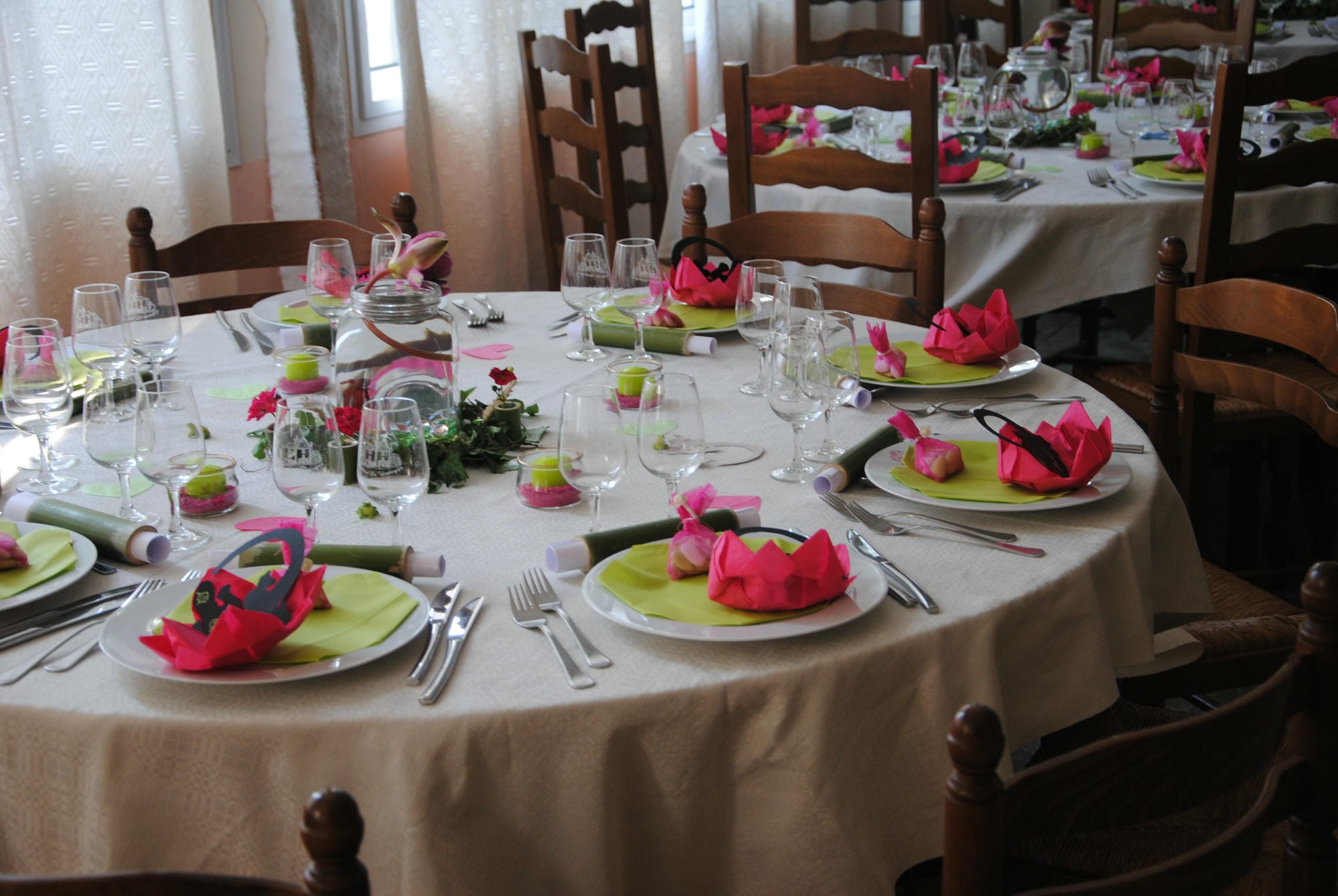 Tables de réception dressées avec serviettes roses et vertes, mariage coloré au Verdoyer