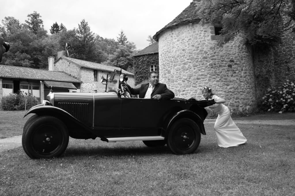 Mariée en robe blanche à côté d'une voiture ancienne, mariage au Château le Verdoyer