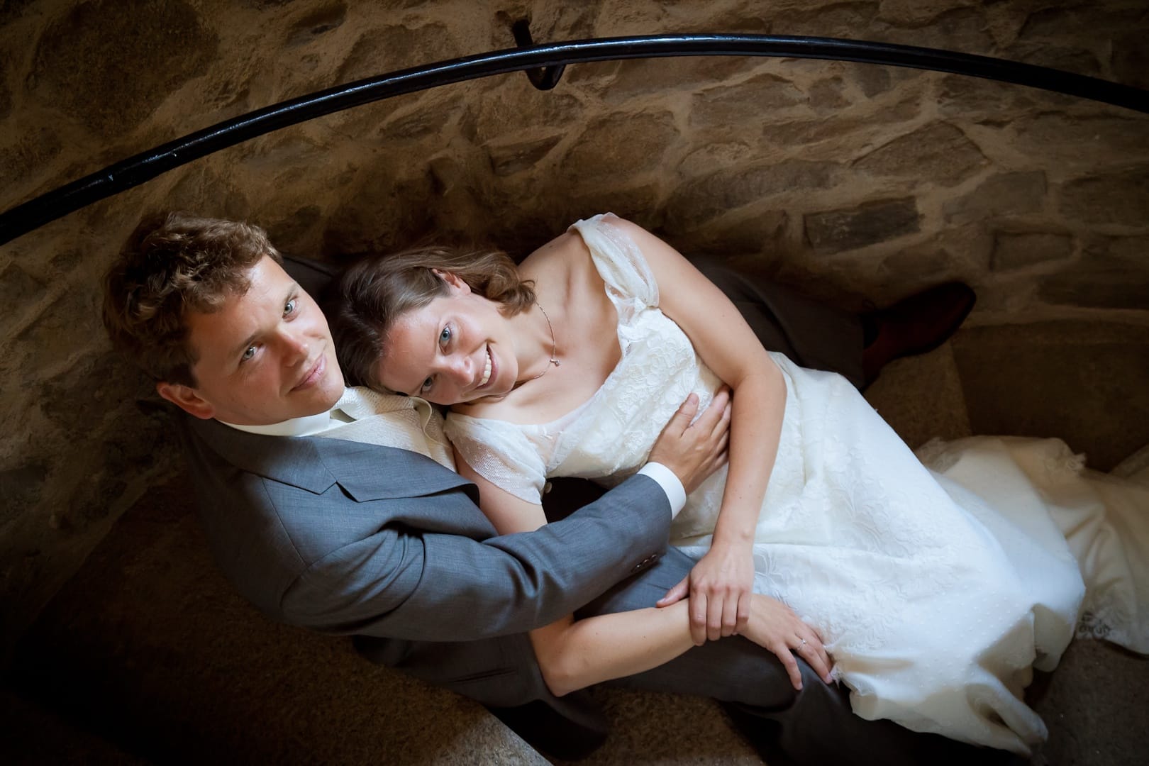 Mariés assis sur des escaliers en pierre, séance photo de mariage au Château le Verdoyer