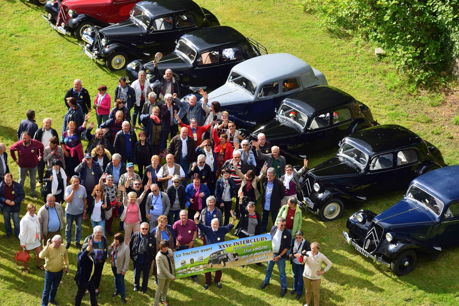 Rassemblement de voitures anciennes avec participants dans un champ, événement au Château le Verdoyer