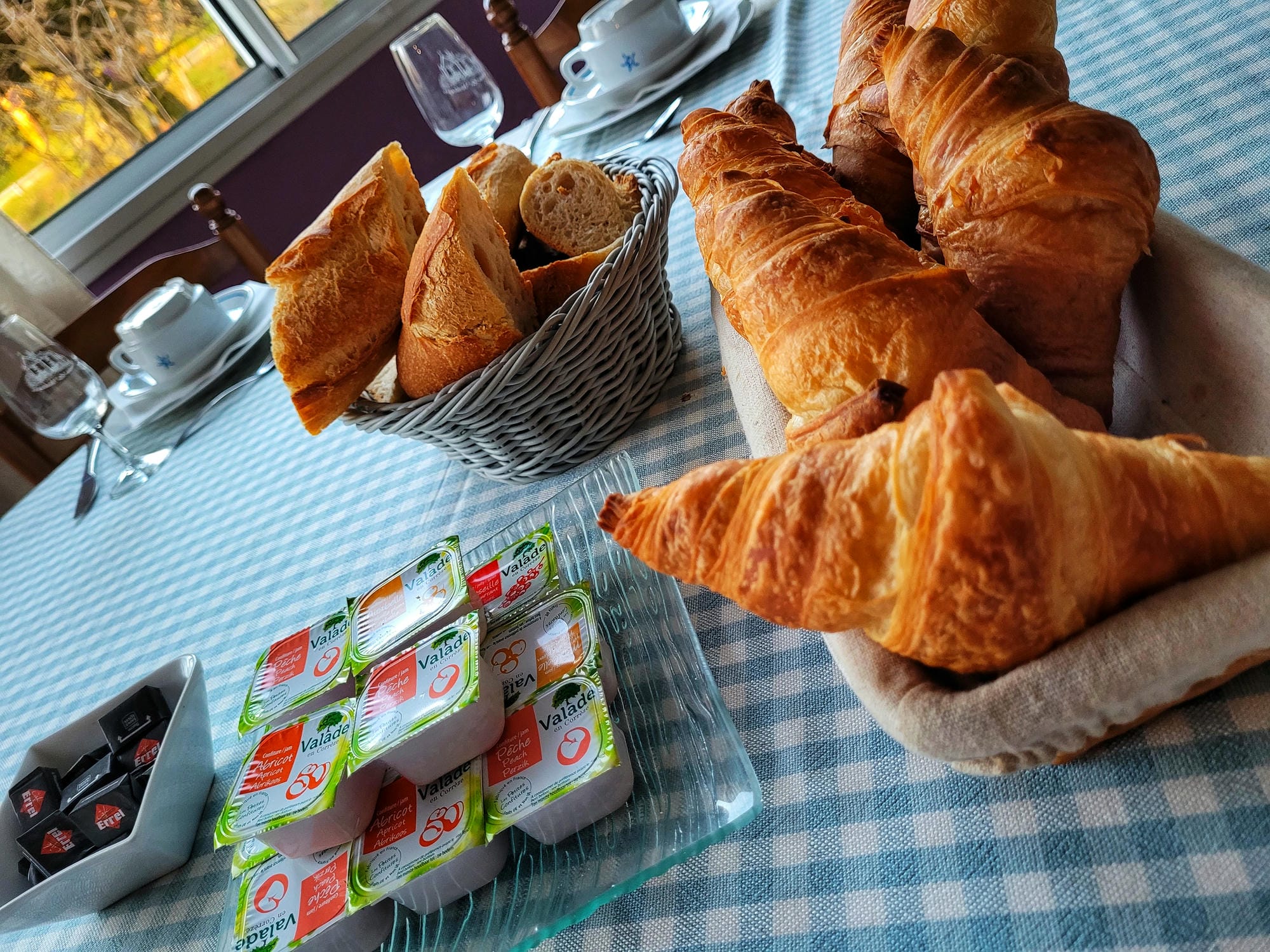 Table de petit-déjeuner copieux avec croissants et autres mets au restaurant du Château le Verdoyer