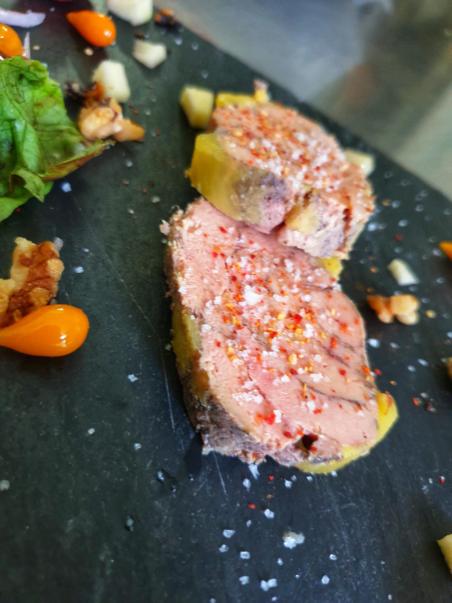 Tranche de foie gras sur assiette noire avec salade, dégustation au restaurant du Château le Verdoyer