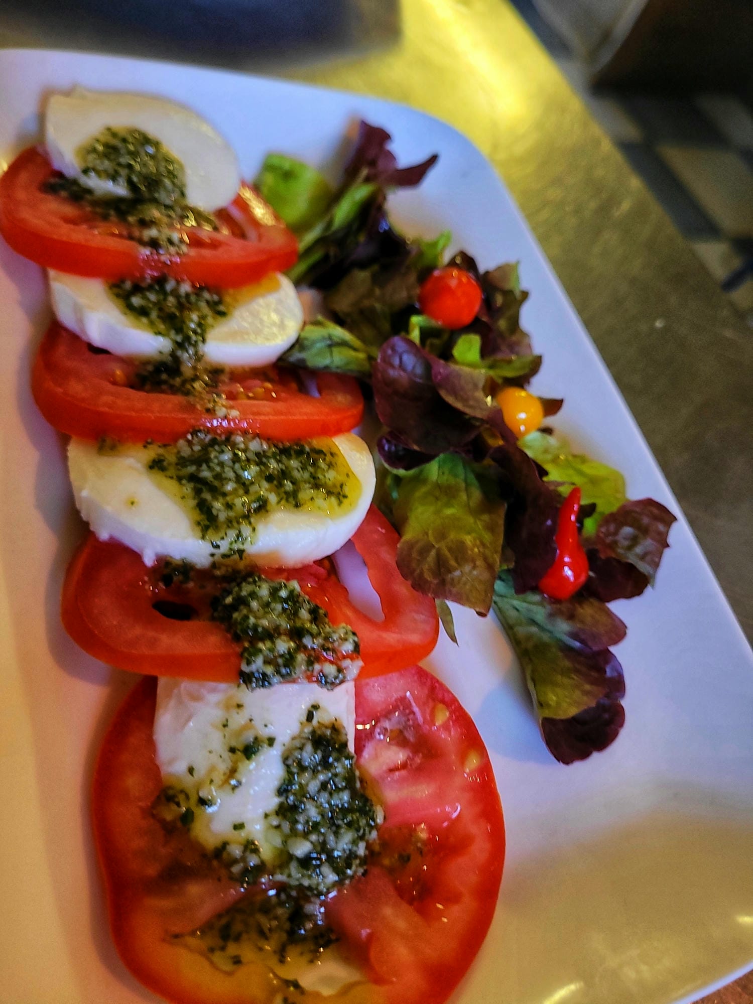 Assiette de tomates mozzarella accompagnée d'une salade, entrée fraîcheur au restaurant du Verdoyer