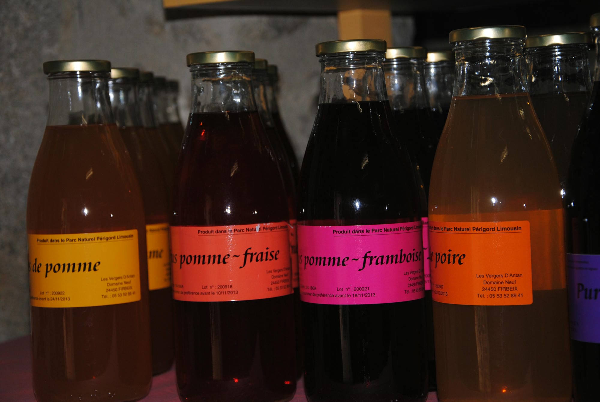 Bouteilles de jus de fruits variés proposées à l'épicerie du Camping Château le Verdoyer