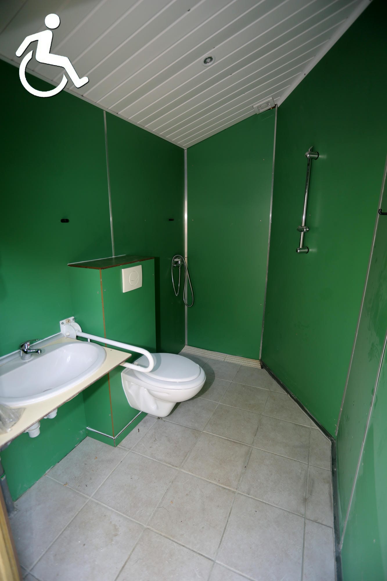 Salle de bain adaptée PMR avec WC, lavabo et pictogramme handicap, Camping Le Verdoyer