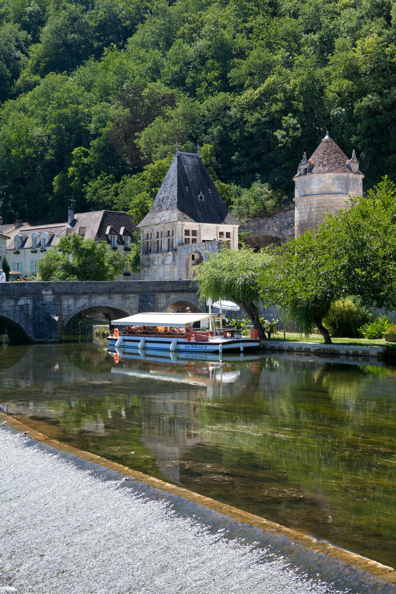 Barque de croisière naviguant sur la Dronne à Brantôme en journée