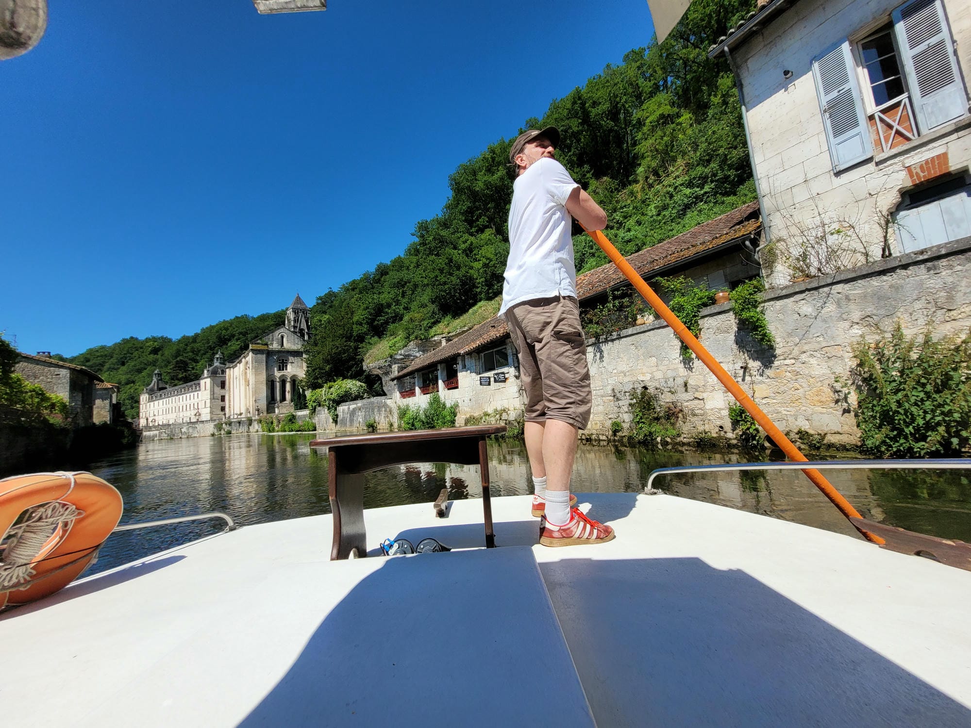 Les Croisières de Brantôme, Homme debout sur une barque avec une pagaie, croisière sur la Dronne à Brantôme