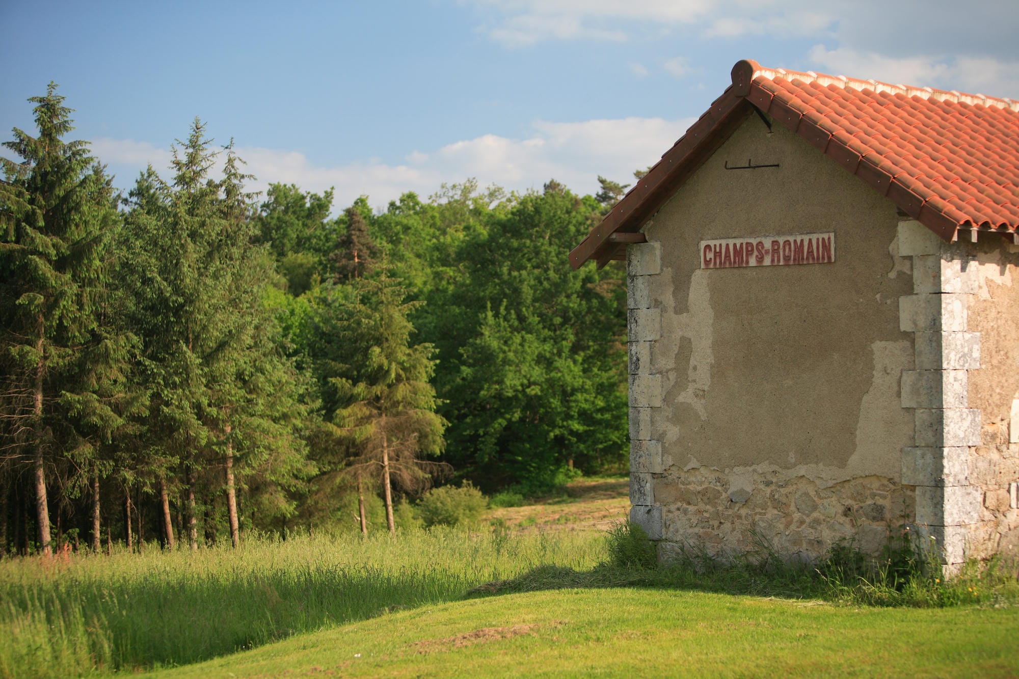 Ancienne gare de Champs-Romain, petit bâtiment avec panneau dans l'herbe