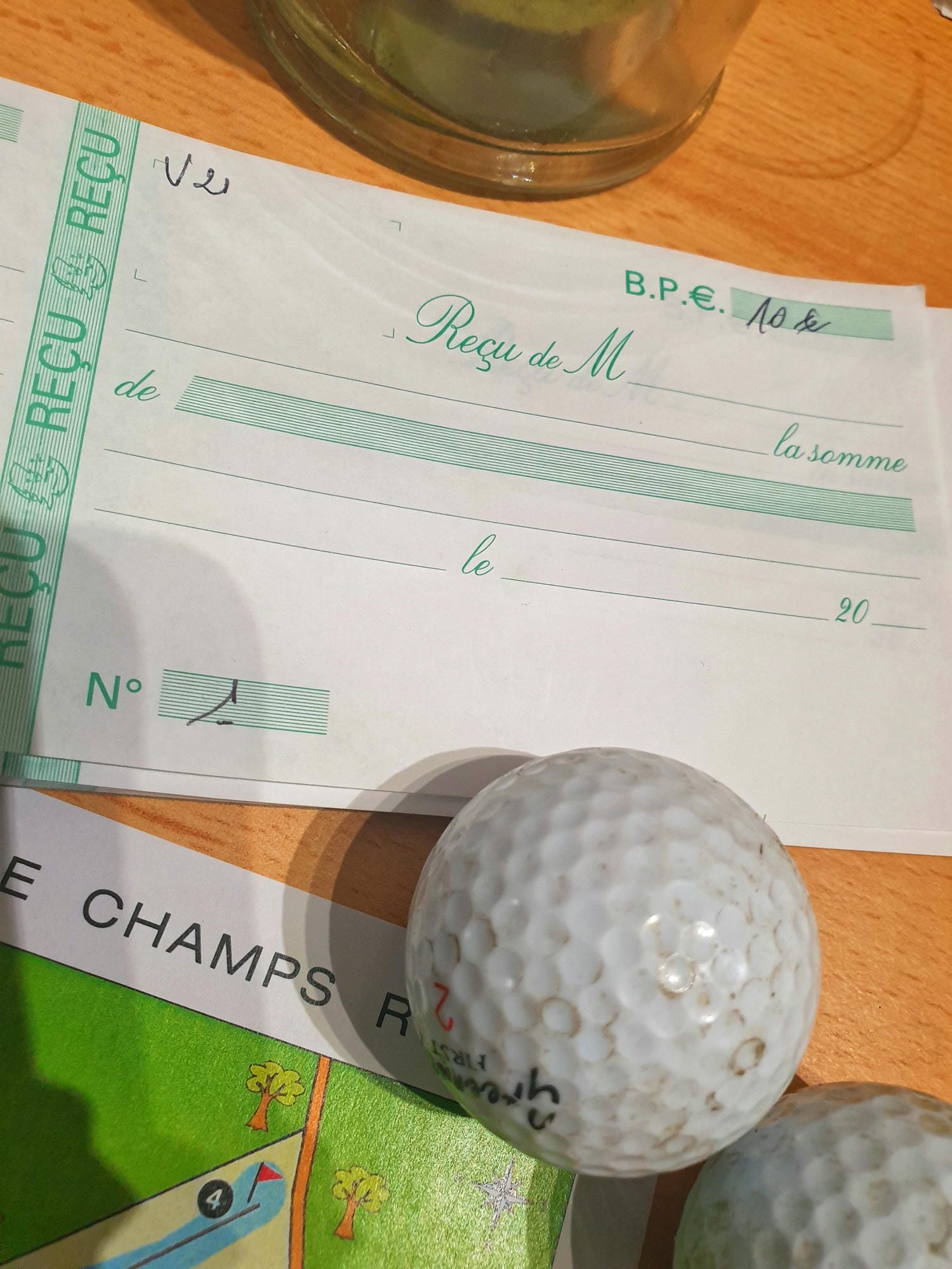 Deux balles de golf et une carte de score sur une table, golf de Champs-Romain