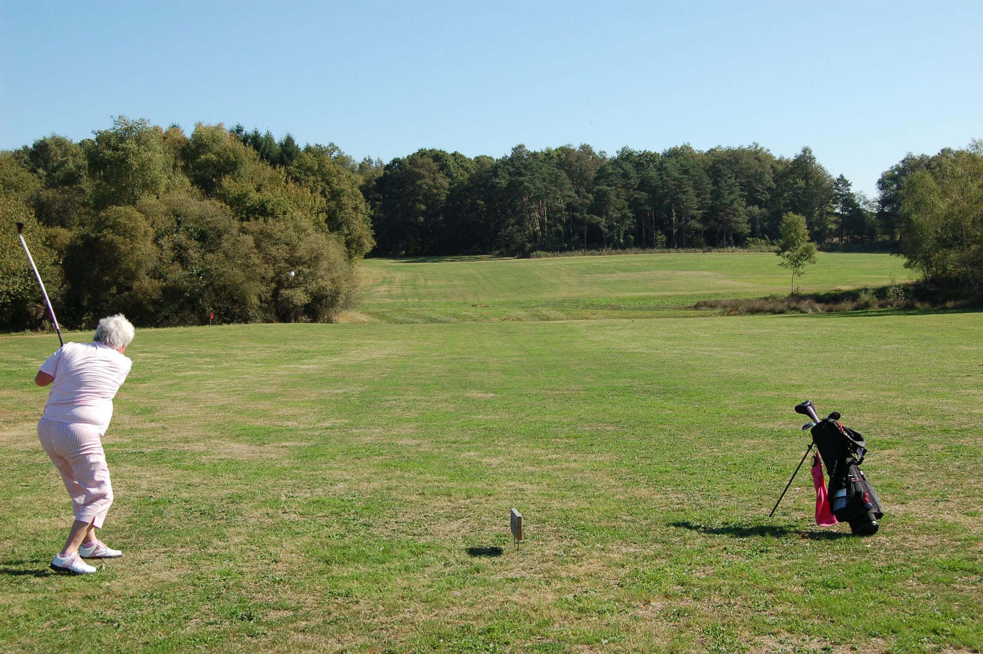 Golfeuse réalisant un swing sur le golf de Champs-Romain en Périgord
