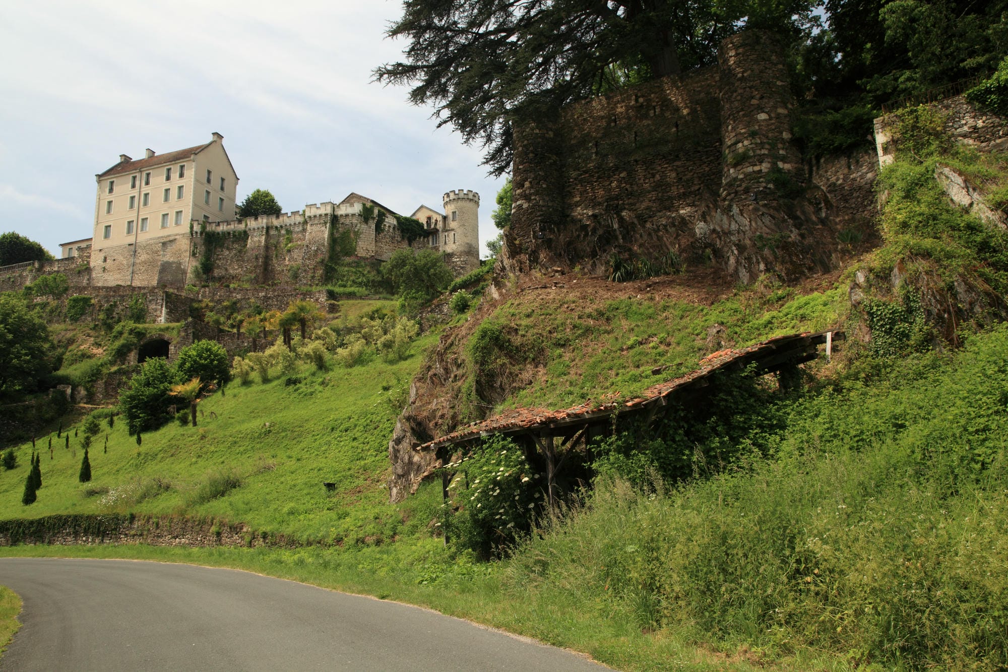 Route montant vers une colline avec le château de Nontron dominant la ville