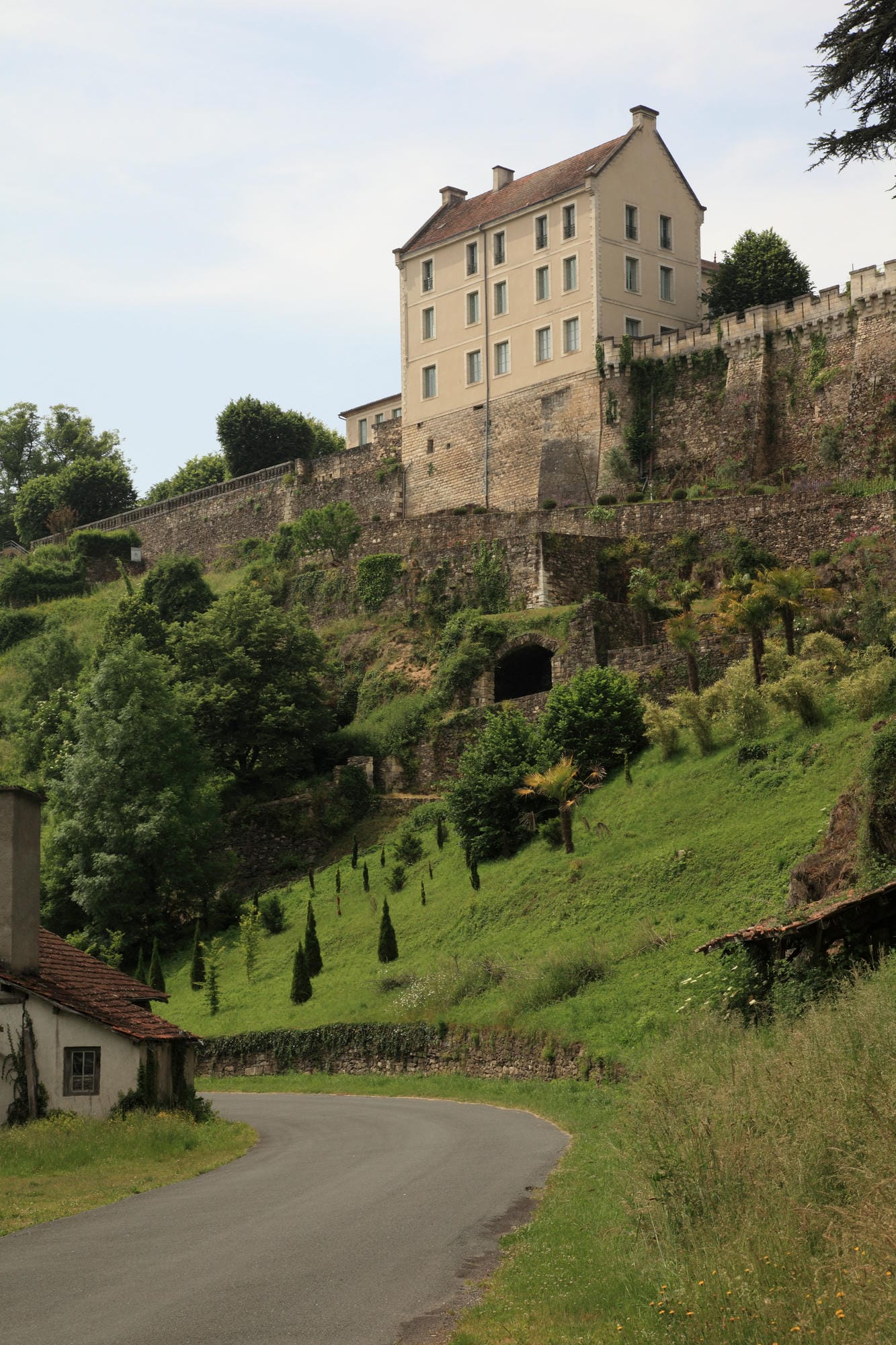 Château de Nontron sur une colline avec route montante à Nontron