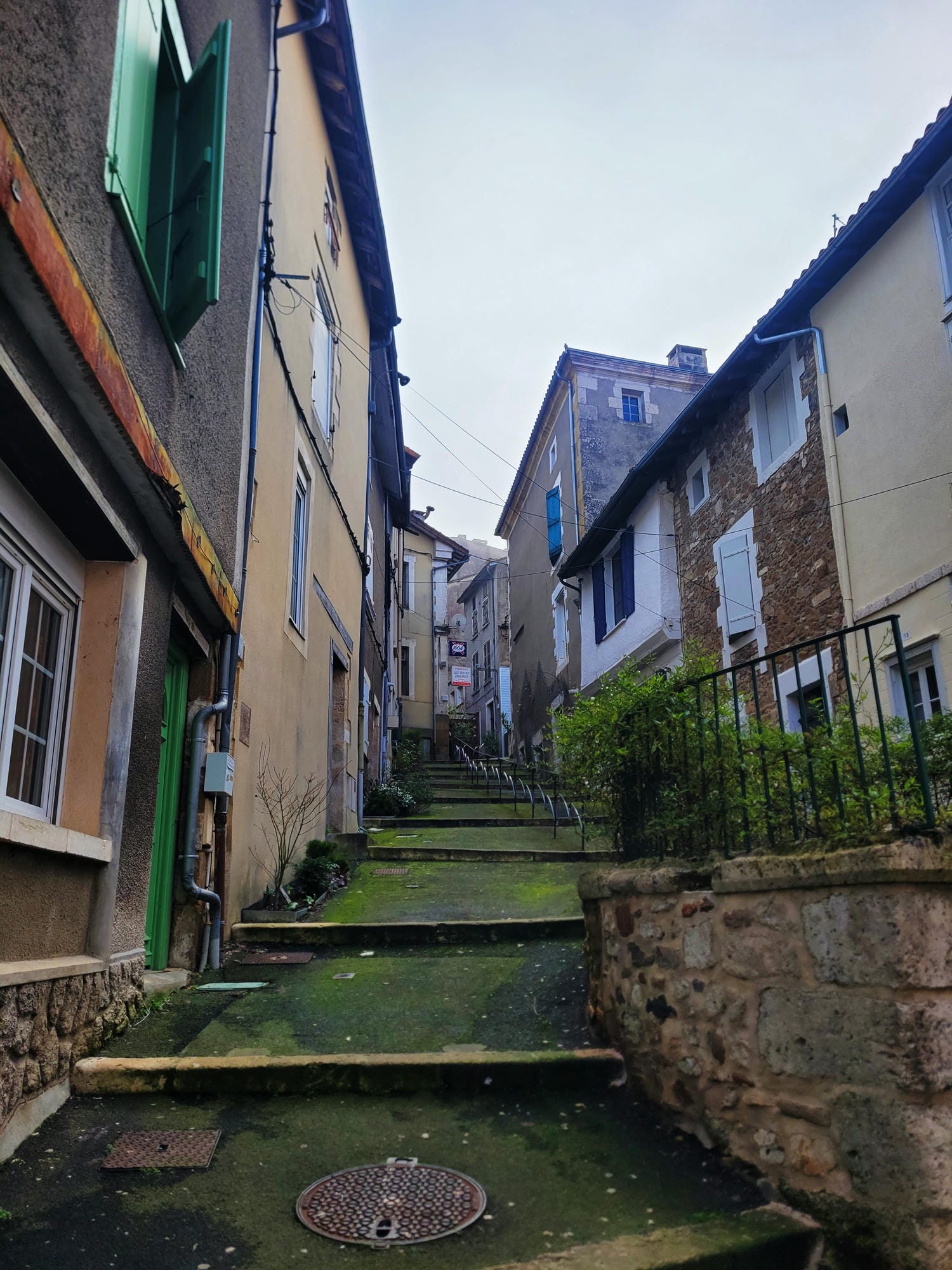 Ruelle étroite en escaliers avec portes vertes, charme du vieux Nontron en Périgord Vert