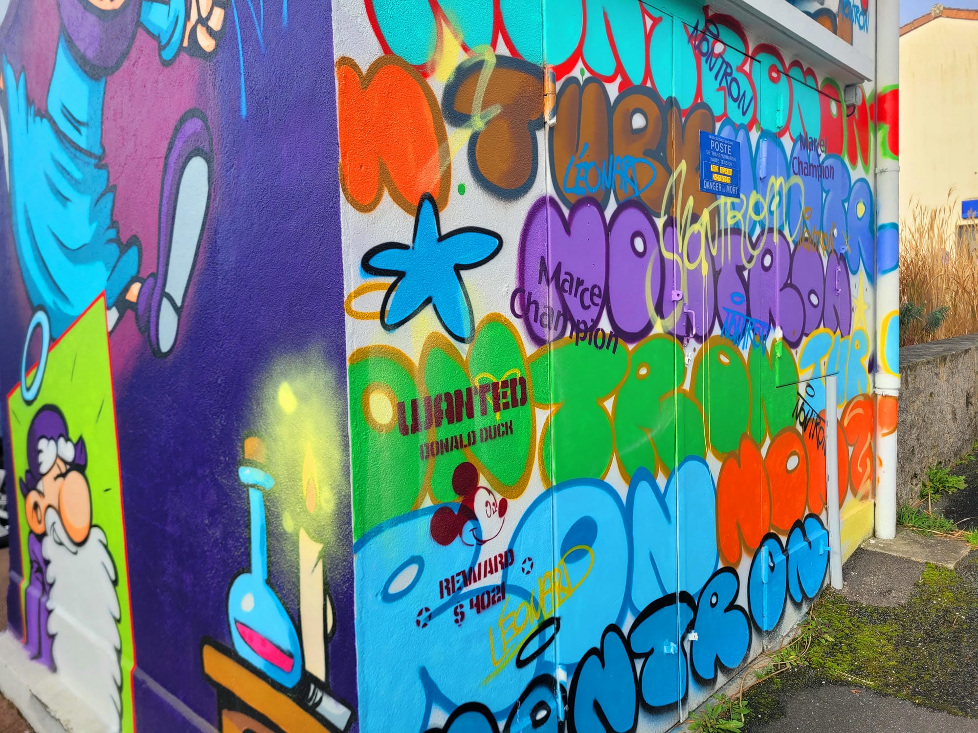 Fresque murale de Marcel Champion sur un bâtiment à Nontron, avec borne d'incendie