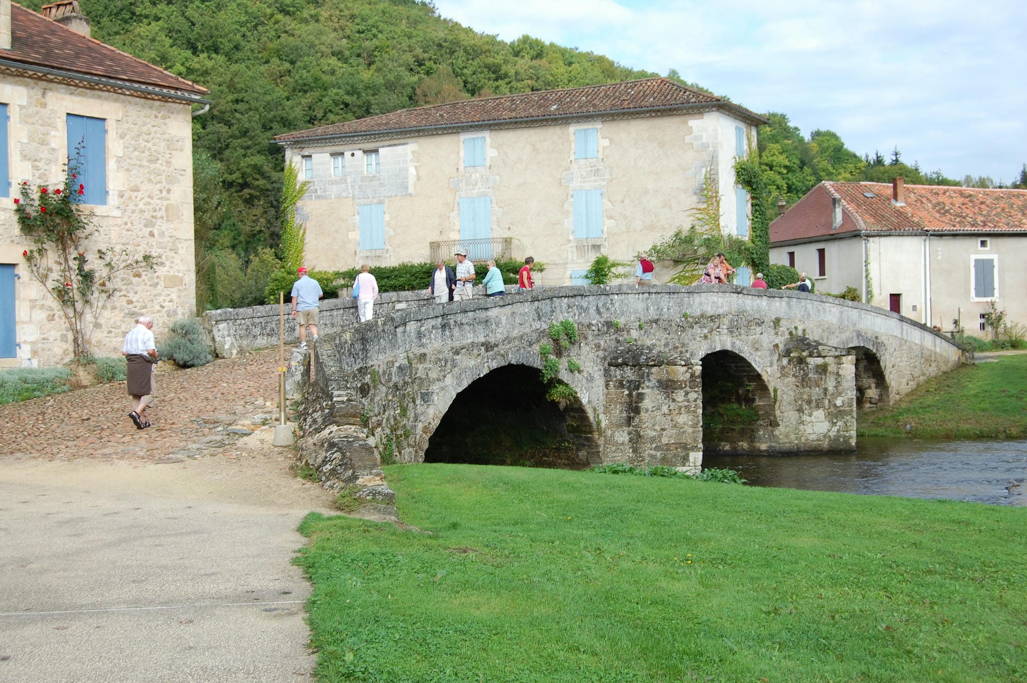 Visiteurs se promenant sur le pont de St-Jean-de-Côle, traversant la rivière Côle