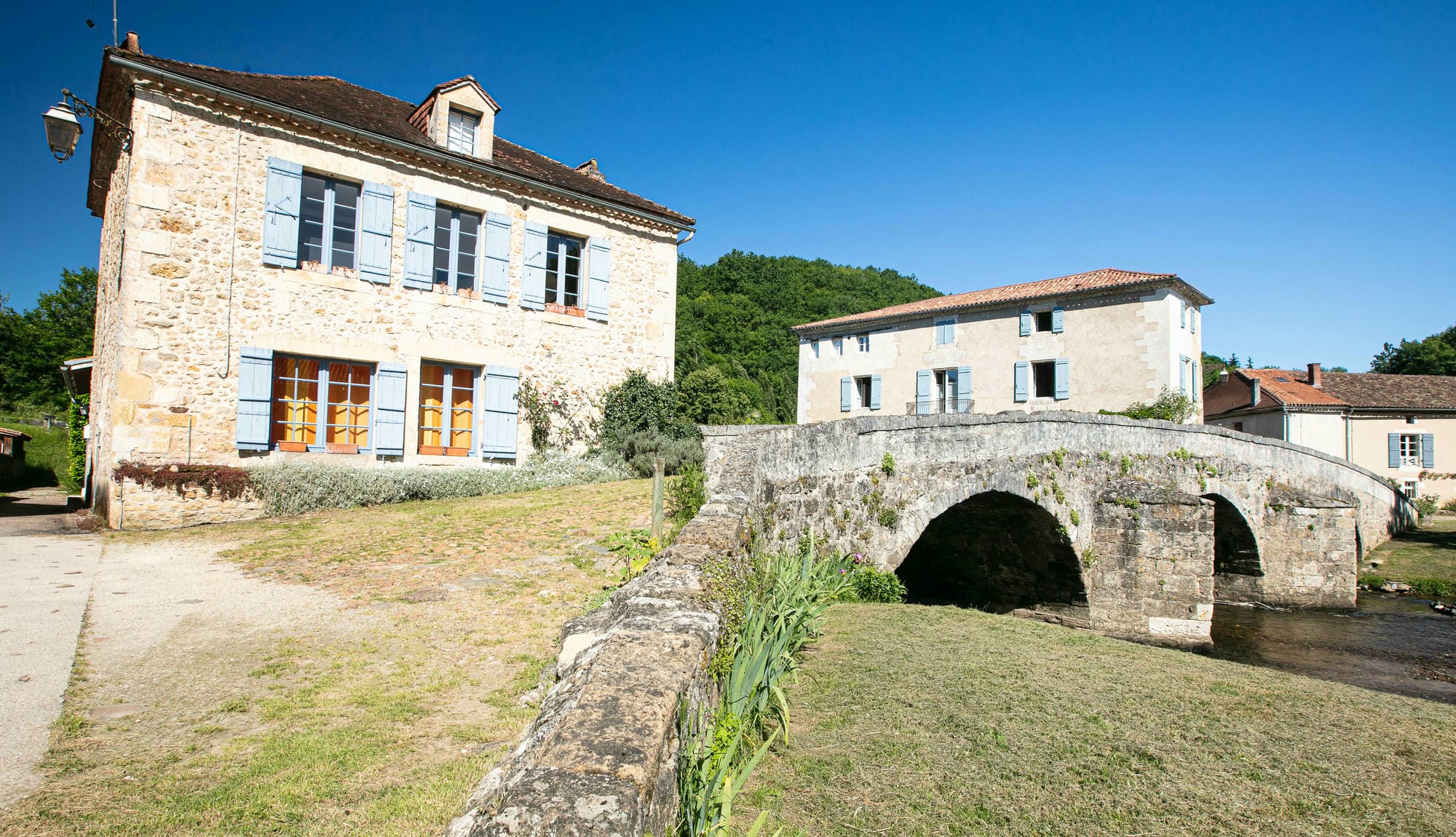 Pont en pierre traversant la Côle devant une maison à St-Jean-de-Côle