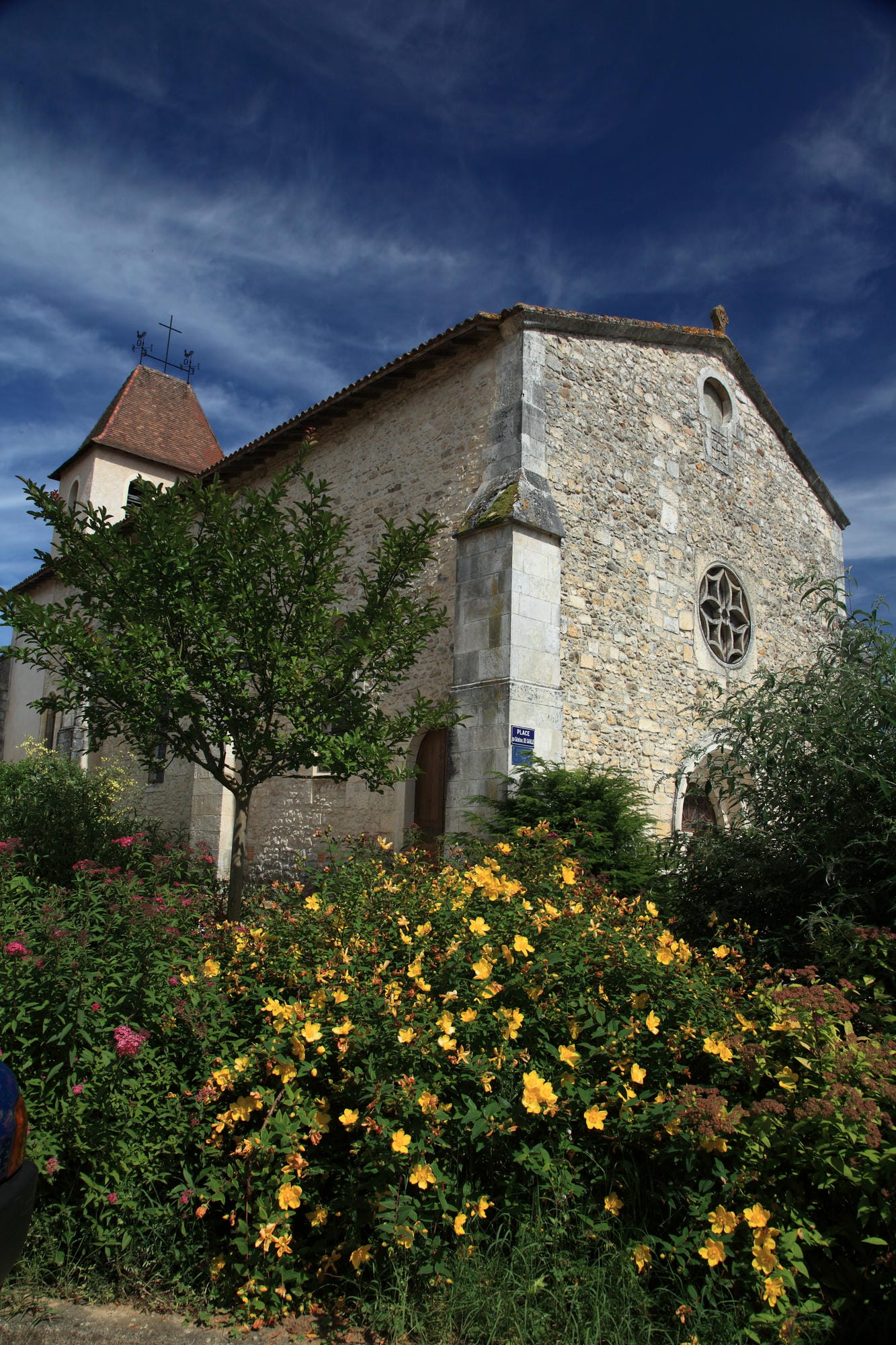 Voiture garée devant une église fleurie à St-Pardoux-la-Rivière, Dordogne