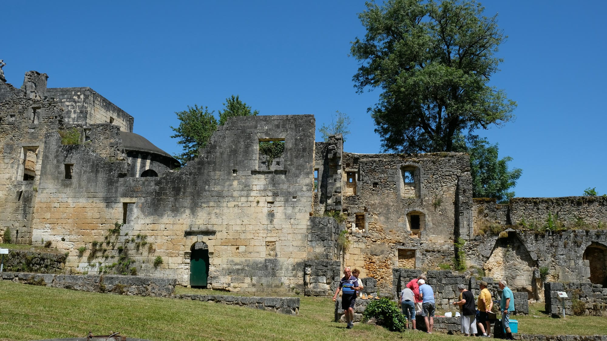 Visiteurs devant les ruines de l'Abbaye de Boschaud à Villars, site historique en Périgord