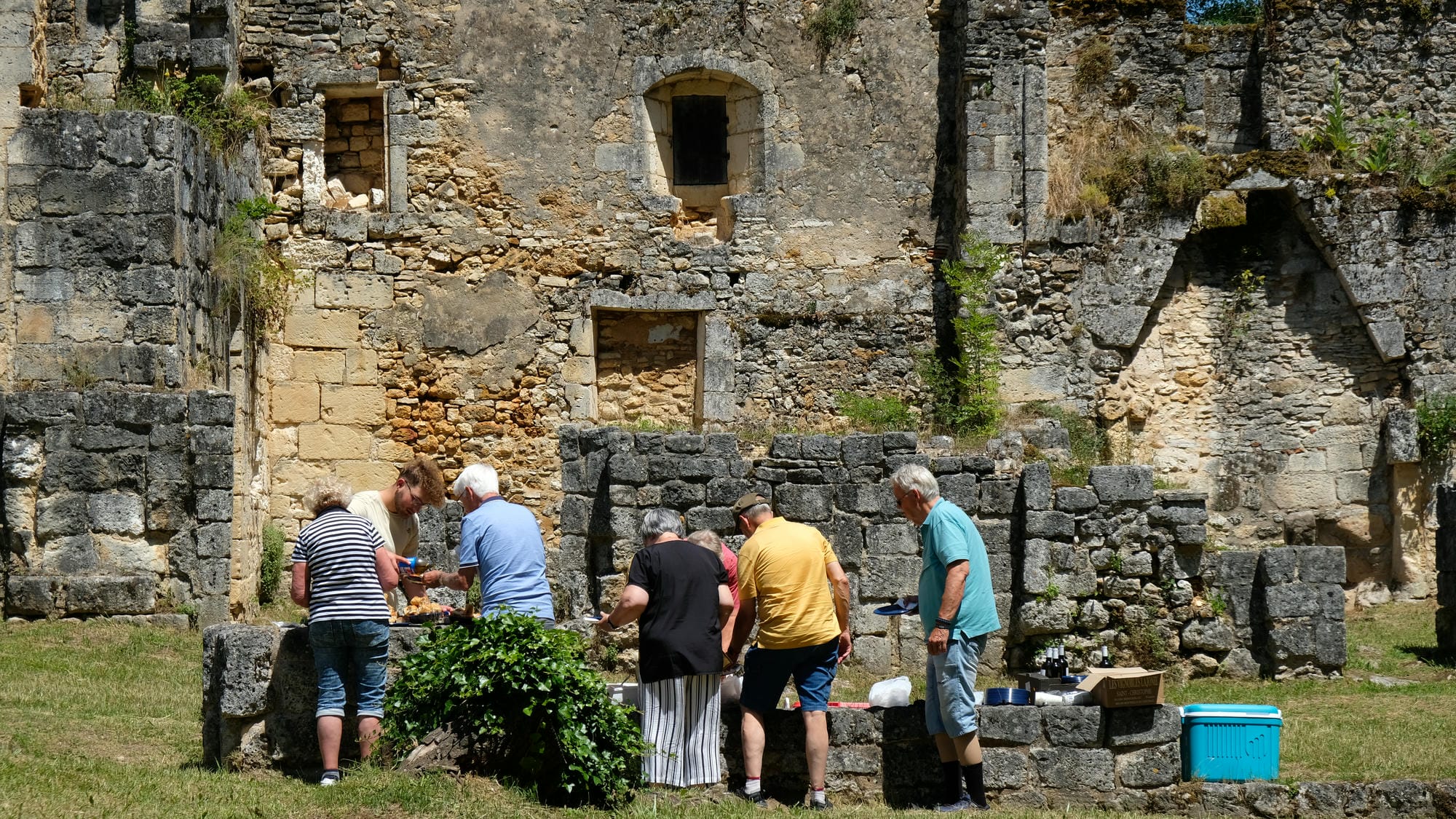 Groupe de personnes autour d'une table garnie de nourriture à l'Abbaye de Boschaud, Villars