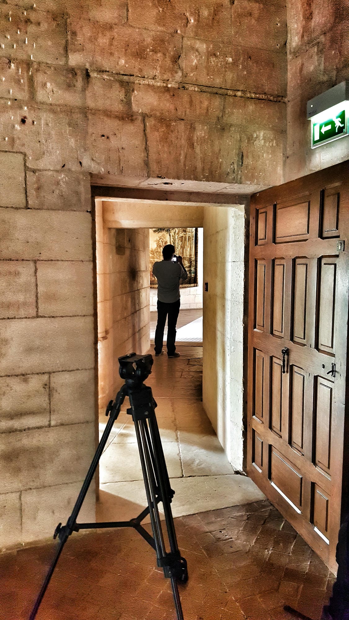 Photographe avec appareil sur trépied dans l'embrasure d'une porte au Château de Puyguilhem