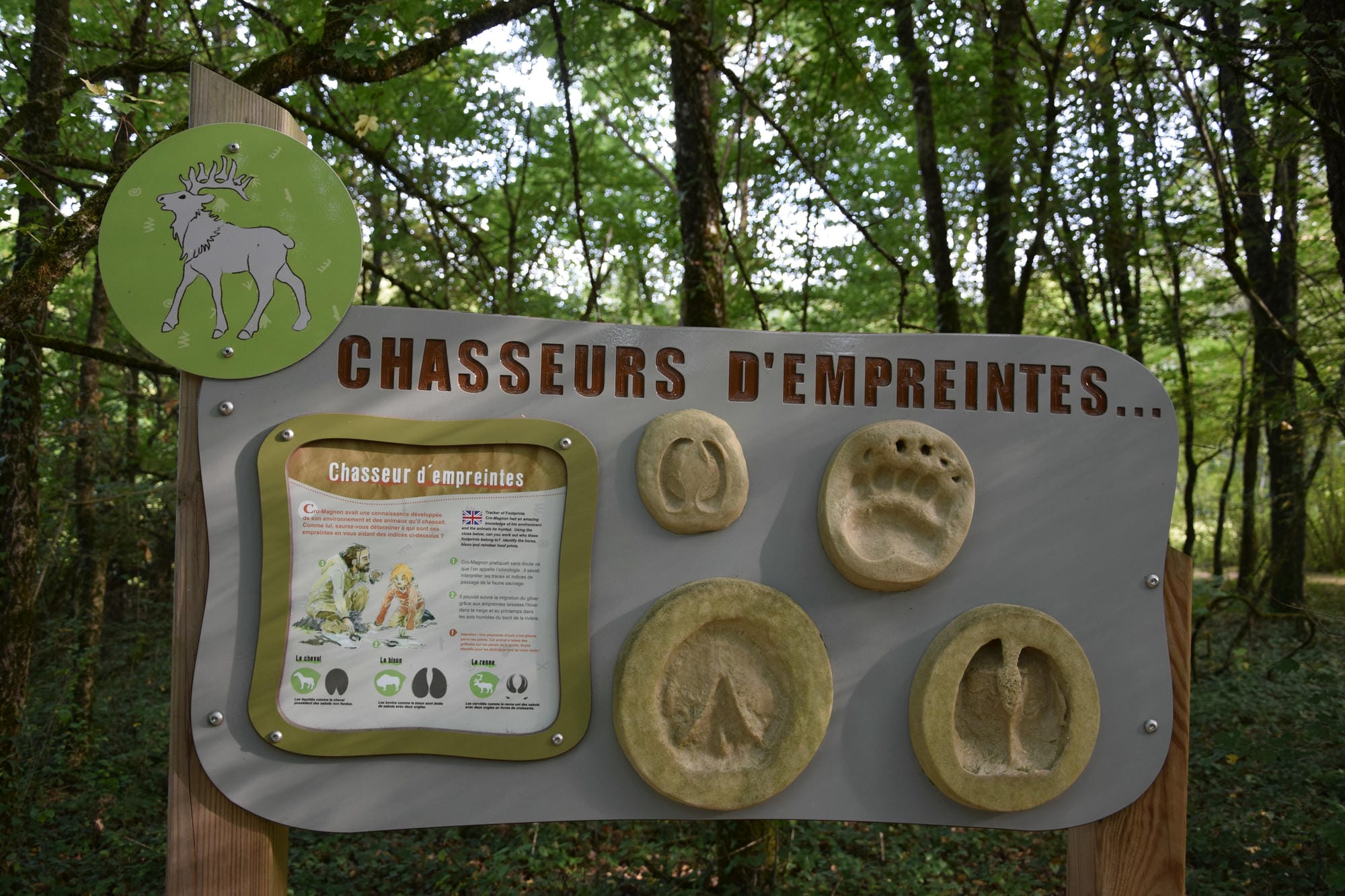 Panneau didactique avec empreintes d'animaux préhistoriques aux Grottes de Villars