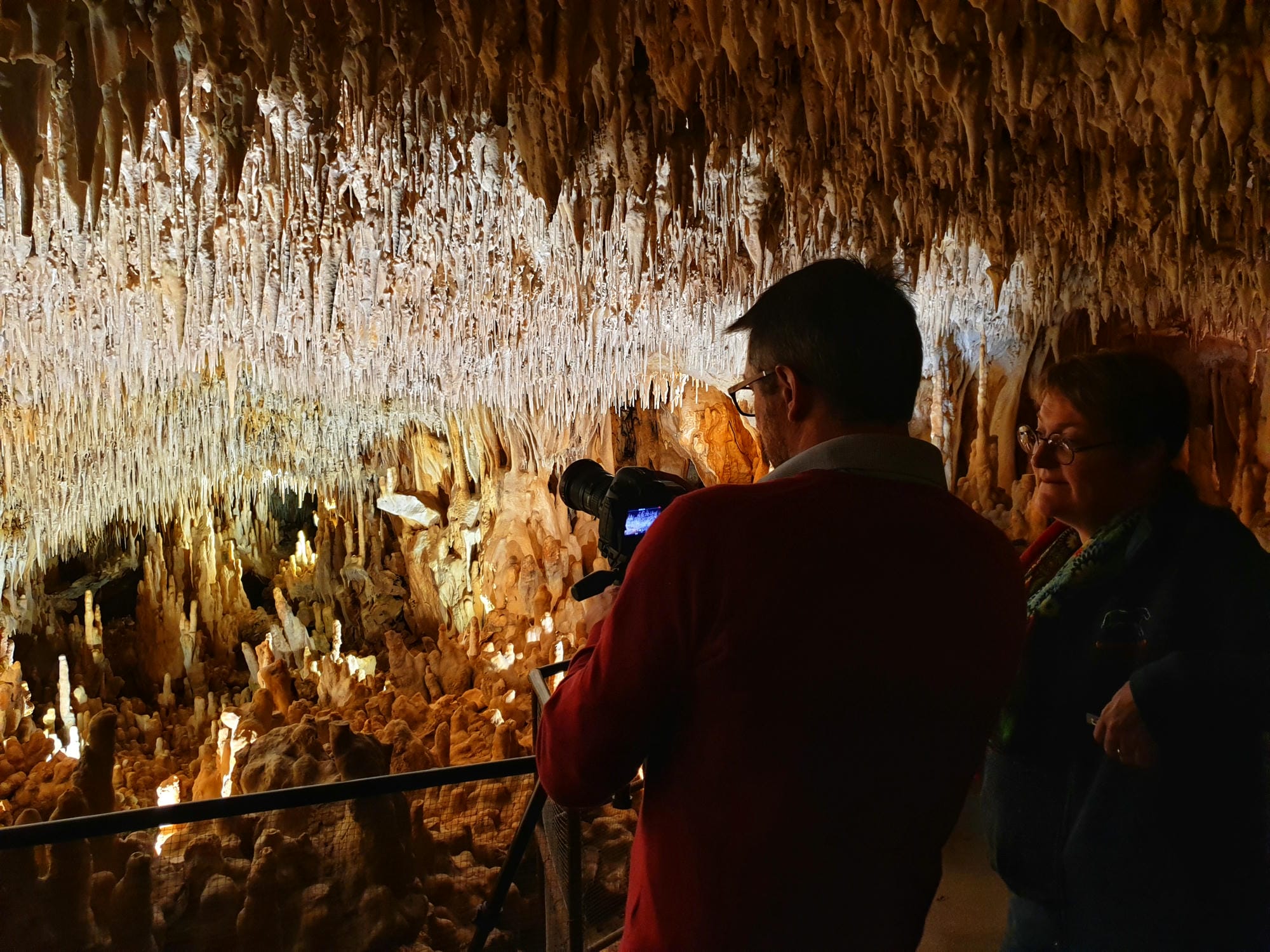 Journaliste photographiant les concrétions des Grottes de Villars