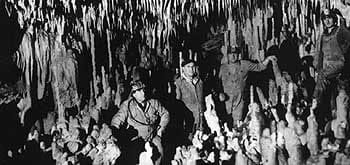 Photo ancienne des premiers explorateurs des Grottes de Villars parmi les concrétions calcaires, histoire de la découverte spéléologique en Périgord